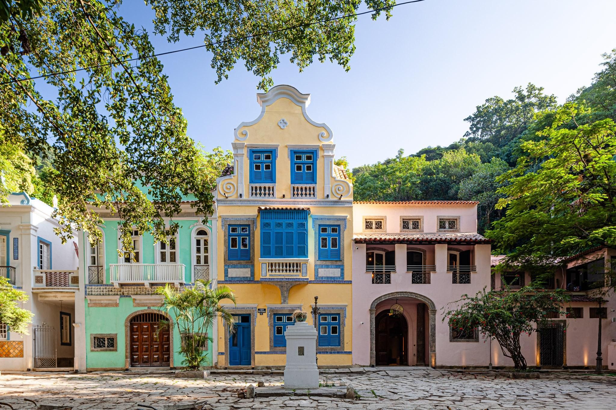 Casas históricas coloridas com fachadas ornamentadas e construções modernas de linhas retas, ilustrando a transformação da arquitetura. Fonte: sympla.com.br
